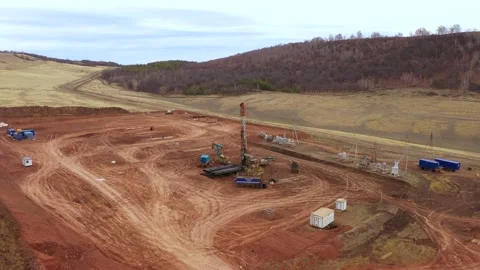 Oil field development. A drilling rig among the hills on a cloudy autumn day. Stock Footage 168640719