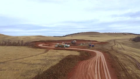 Oil field development. A drilling rig among the hills on a cloudy autumn day. Stock Footage 168789863