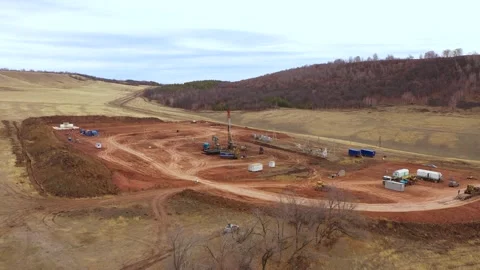 Oil field development. A drilling rig among the hills on a cloudy autumn day. Stock-Footage 168920081