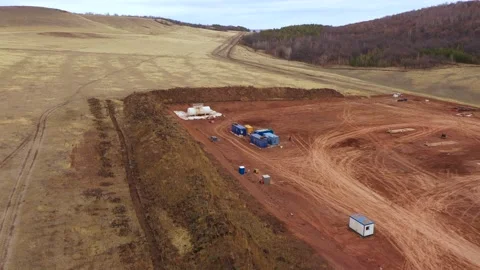 Oil field development. A drilling rig among the hills on a cloudy autumn day. Video stock 169073422