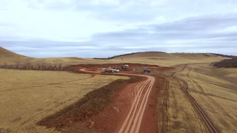 Oil field development. A drilling rig among the hills on a cloudy autumn day. Stock Footage 170331746