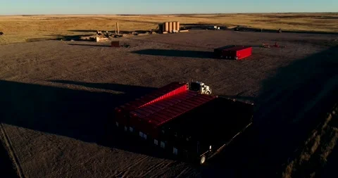 Oil field fracking pad preparation during sunset. A drone orbital shot Stock Footage 167622532