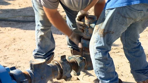 Oil field workers prep fracking equipment in petroleum field Stock Footage 125685091