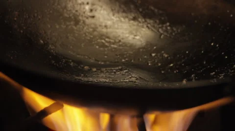 Oil Heating Up and Bubbling Within a Wok on a Burner Stock Footage 1039331