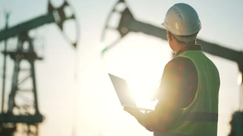 Oil industry. Engineer worker makes notes on operation of an oil pump. The Stock Footage 230102395