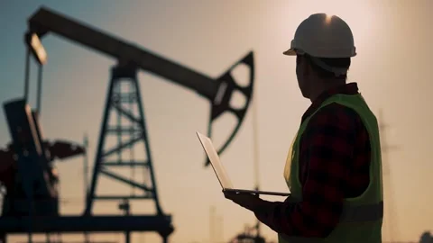 Oil industry. Engineer worker makes notes on operation of an oil pump. The Stock Footage 255901200