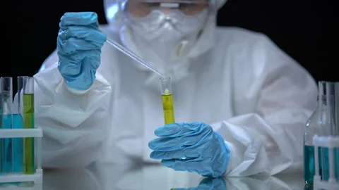 Oil lab worker examining composition of fuel marked as extremely flammable Stock Footage 115417017