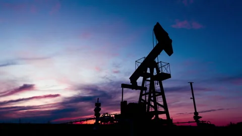 Oil pump on a background of crimson clouds 库存影片 131095126