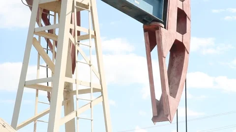 Oil pump close up on a background of blue sky with clouds on a summer day Stock Footage 137779328