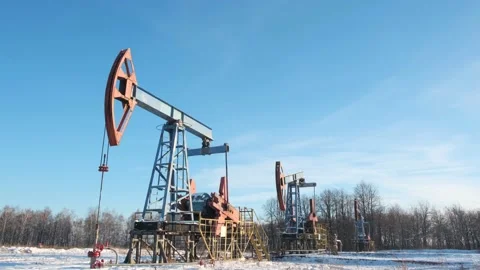 Oil pump drilling rig or rocking machine against the blue winter sky. Cold Stock Footage 147246027