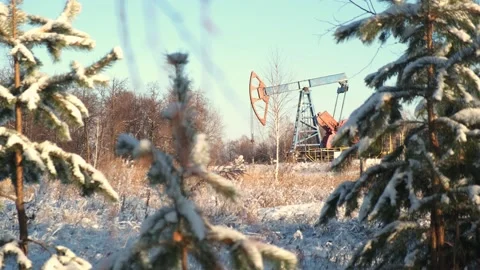 Oil pump drilling rig or rocking machine against the blue winter sky. Cold Stock Footage 147246113