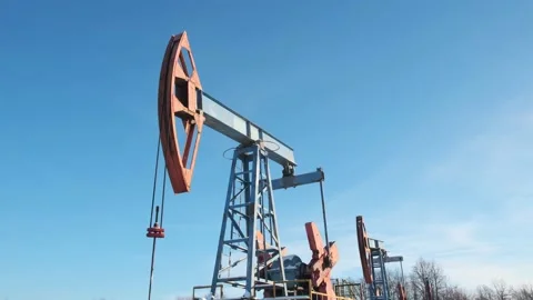 Oil pump drilling rig or rocking machine against the blue winter sky. Cold Stock Footage 147386031