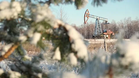 Oil pump drilling rig or rocking machine against the blue winter sky. Cold Stock Footage 147386277