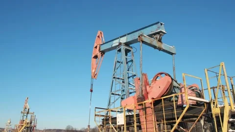 Oil pump drilling rig or rocking machine against the blue winter sky. Cold Stock Footage 149406786