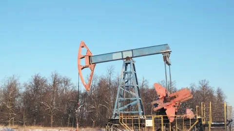 Oil pump drilling rig or rocking machine against the blue winter sky. Cold 動画素材 156728527