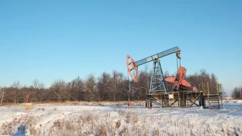 Oil pump drilling rig or rocking machine against the blue winter sky. Cold Stock Footage 156729260
