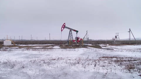 An oil pump in a field pumps raw product for sale and processing Stock Footage 238075482