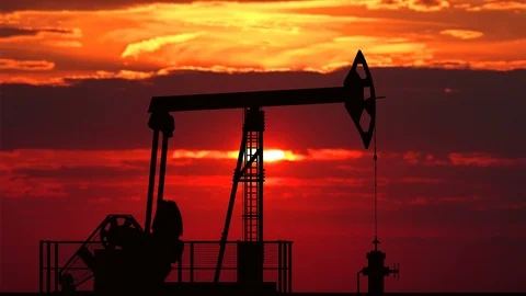 Oil pump jack against red sunset Stock Footage 87607610
