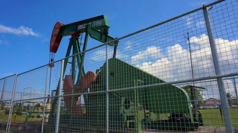 Oil pump jack in work. Oil industry in Seria, Brunei Darussalam on a sunny day Stock Footage 32700530