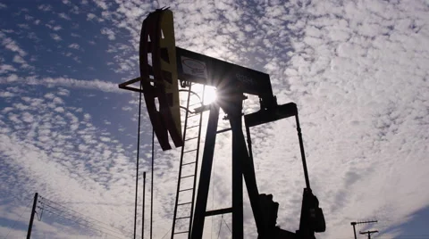 Oil Pump silhouette Low Angle back lit by the sun Stock Footage 68868893