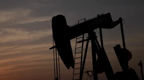 Oil pump working at dusk in the desert Stock Footage 58606237