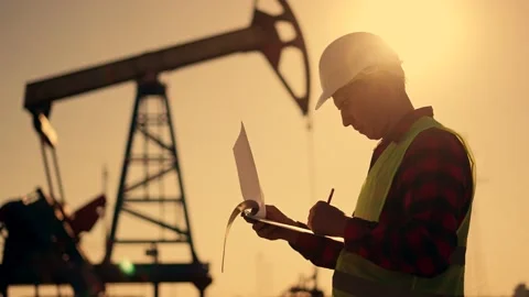 Oil pump.Engineer work with laptop and diagram.Checking operation of oil pump at Stock Footage 235337856