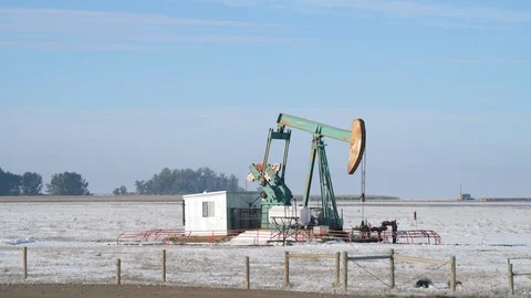 Oil pumpjack operating in a snowy field on a foggy morning Stock-Footage 117965596