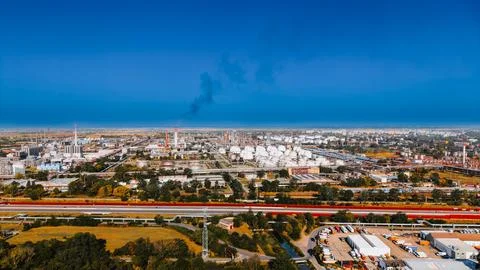 Oil refinery complex with storage tanks beneath storm clouds. Aerial panora.. Stock Photos