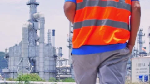 Oil refinery engineer walking through an industrial processing area while inspec Vídeo Stock 347143768
