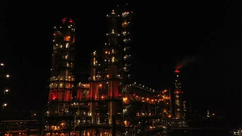 Oil refinery with illumination. Columns, reactors, pipes in color light. Evening Stock Footage 240849197