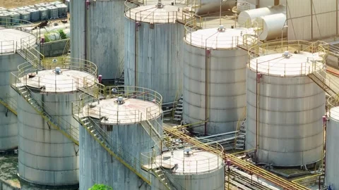 An oil refinery with large storage tanks and pipelines. Video stock 331571399