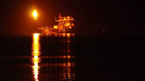 Oil rig, offshore facility in the ocean at night with flaming torch. Stock Footage