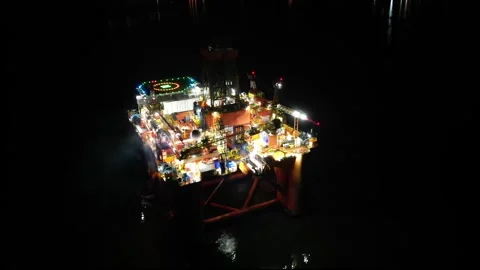 Oil rig platform close up aerial circling shot night dark helipad steam unmarked Stock Footage 276261504