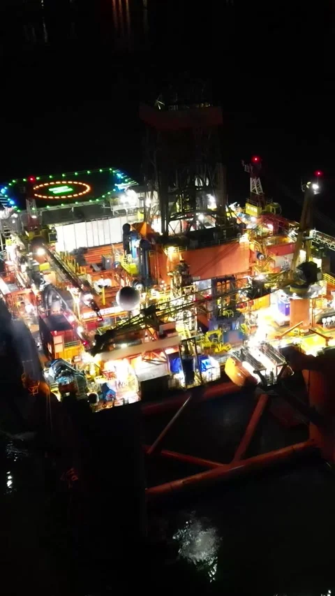 Oil rig platform close up aerial circling shot night dark helipad steam unmarked Stock Footage 281500616
