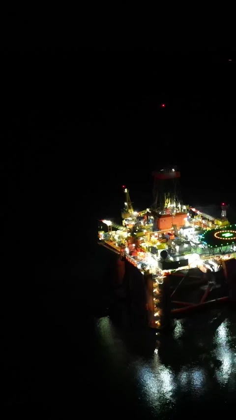 Oil rig platform drilling circling aerial night dark black revealing a second Stock Footage 281500327