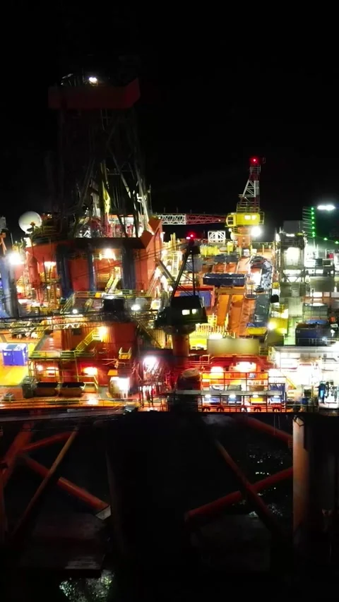 Oil rig platform drilling offshore aerial night circling shot illuminated Stock Footage 281500913