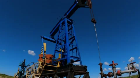 Oil rig in the process of work, an oil rig pumps oil on a clear sunny day Video stock 194587793