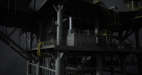 Oil rig structure illuminated at night over dark water in remote location Stock Footage 326348543