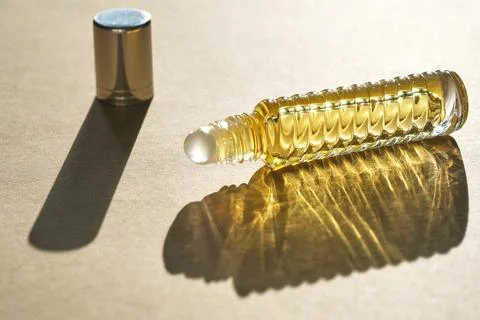 Oil roller perfume on a beige background. Stock Photos