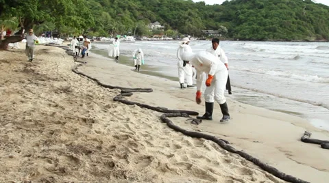 OIL SPILL DISASTER WORKERS CLEAN TROPICAL BEACH Stock Footage 27570388