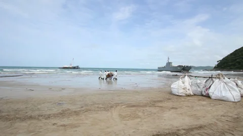 OIL SPILL DISASTER WORKERS CLEAN TROPICAL BEACH Stock Footage 27622604