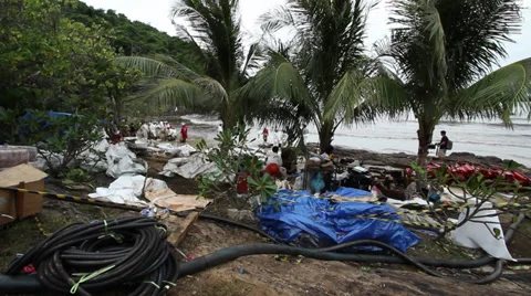 OIL SPILL DISASTER WORKERS CLEAN TROPICAL BEACH Stock Footage 27638683