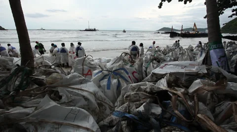 OIL SPILL DISASTER WORKERS CLEAN TROPICAL BEACH Stock Footage 27640206