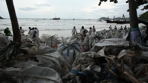 OIL SPILL DISASTER WORKERS CLEAN TROPICAL BEACH Stock Footage 27642656