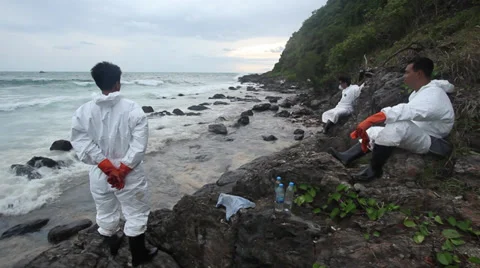 OIL SPILL DISASTER WORKERS CLEAN TROPICAL BEACH Stock Footage 27643747