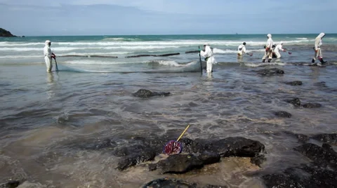 OIL SPILL DISASTER WORKERS CLEAN TROPICAL BEACH Stock Footage 27645757
