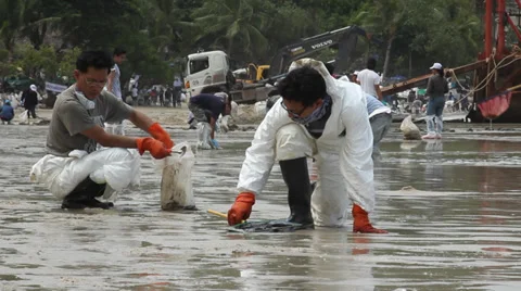 OIL SPILL DISASTER WORKERS CLEAN TROPICAL BEACH Stock Footage 27653393
