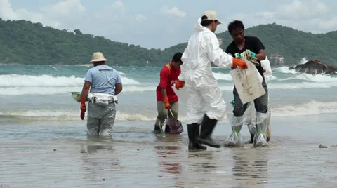 OIL SPILL DISASTER WORKERS CLEAN TROPICAL BEACH Stock Footage 27658491