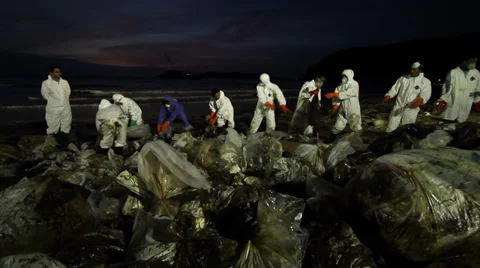 OIL SPILL DISASTER WORKERS NIGHTTIME CLEAN UP Stock Footage 27828236