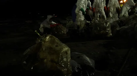 OIL SPILL DISASTER WORKERS NIGHTTIME CLEAN UP Stock Footage 27829418